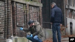 Polisi Belgia meneliti sebuah bangunan di pinggir jalan di Verviers, Belgia (Jumat, 16/1). Jalan itu diblokir setelah polisi berhasil mencegah aksi terorisme sehari sebelumnya yang menewaskan 2 orang dan seorang ditangkap. 