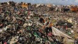 Seorang anak laki-laki mencari barang-barang bekas yang masih bisa didaur ulang di tempat pembuangan sampah di Antang, Sulawesi Selatan (26/1). (Foto: Andri Saputra /AFP)