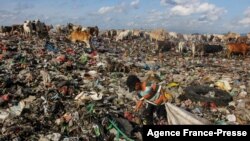 A boy searches for useable things at a garbage dump in Antang, Indonesia.