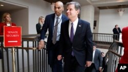 FBI Director Christopher Wray, right, leaves a classified briefing about the federal investigation into President Donald Trump's 2016 campaign, on Capitol Hill in Washington, May 24, 2018.