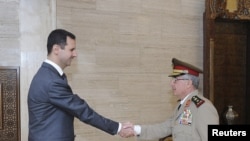 Syria's President Bashar al-Assad (L) welcomes new Chief of General Staff of the Army and the Armed Forces, General Ali Abdullah Ayyoub, before a meeting in Damascus, July 22, 2012.