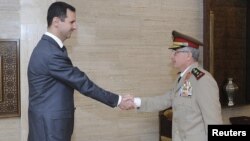 Syria's President Bashar al-Assad (L) welcomes new Chief of General Staff of the Army and the Armed Forces, General Ali Abdullah Ayyoub, before a meeting in Damascus, July 22, 2012. 