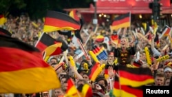 German soccer fans watch the 2014 World Cup Group G soccer match between Germany and Ghana at a public viewing zone called 'fan mile' in Berlin, June 21, 2014.