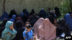 Sejumlah perempuan Afghanistan mengantre bersama anak mereka untuk menerima bantuan makanan yang dibagikan oleh International Committee of the Red Cross (ICRC) di distrik Ghani Khel, provinsi Nangarhar, pada 4 September 2023. (Foto: AFP/Shafiullah Kakar)