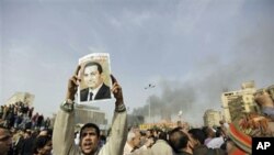 میسریه‌کی به‌شـداربووی خۆپـیشـاندانێـکی قاهیره‌ وێنه‌یه‌کی حوسنی موباره‌کی به‌رزکردۆته‌وه‌ و له‌سه‌ری نووسراو " ئه‌ی موباره‌ک بڕۆ"، شه‌ممه‌ 29 ی یه‌کی 2011