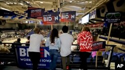 Younger caucusgoers hold signs for Democratic presidential candidate Joe Biden at the Knapp Center on the Drake University campus in Des Moines, Iowa, Feb. 3, 2020.
