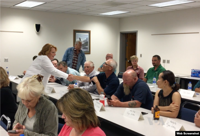 La senadora demócrata Heidi Heitkamp, ​​de Dakota del Norte, a la izquierda, vestida de blanco, habló recientemente a los granjeros de Valley City y propietarios de pequeños negocios en una mesa redonda sobre economía.