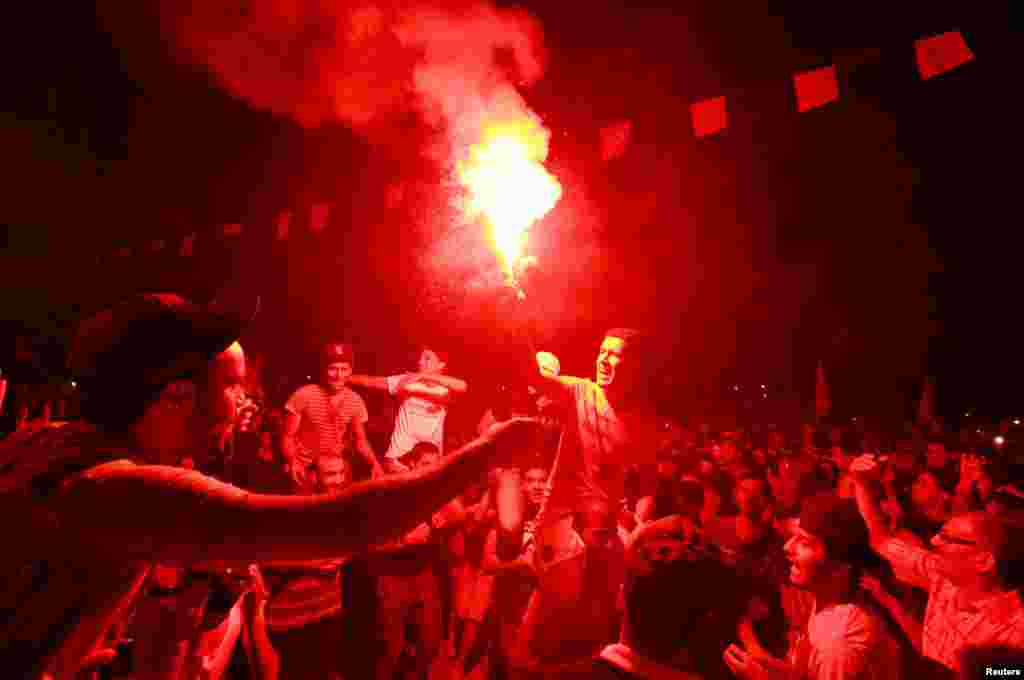 A man lights a flare outside the Constituent Assembly headquarters during a protest to demand the ouster of the Islamist-dominated government, Tunis, July 28, 2013.