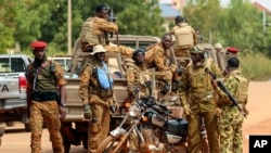 FILE: Burkina army soldiers gather outside the National Assembly in Ouagadougou, Burkina Faso, Friday Oct. 14, 2022. Authorities say the persons who killed some 60 persons wore army uniforms.