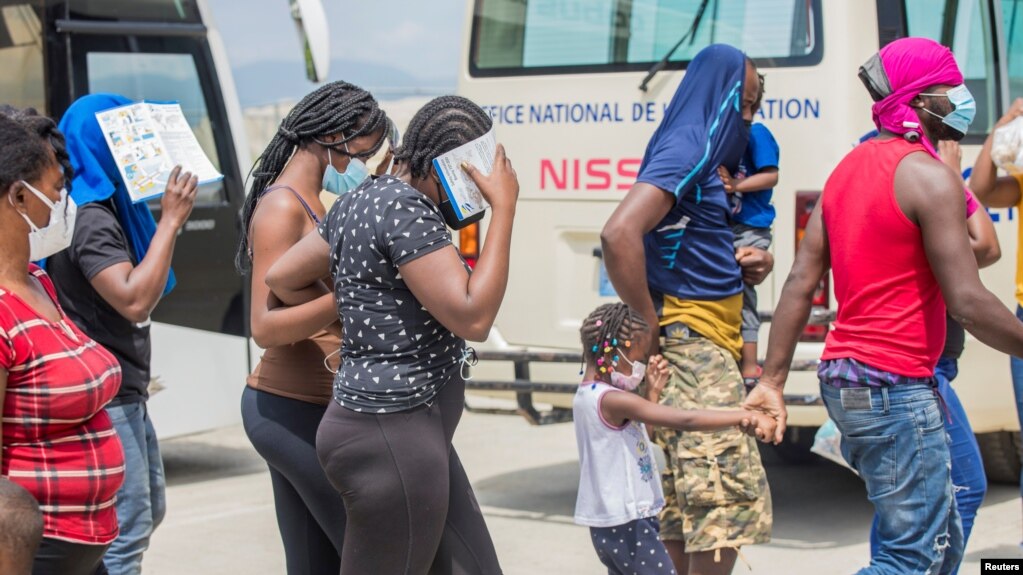 Los migrantes haitianos caminan juntos después de que las autoridades estadounidenses los sacaron de una ciudad fronteriza de Texas el domingo 19, donde miles de personas, en su mayoría haitianos, se habían reunido debajo de un puente después de cruzar el río Grande desde México.