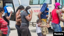 Los migrantes haitianos caminan juntos después de que las autoridades estadounidenses los sacaron de una ciudad fronteriza de Texas el domingo 19, donde miles de personas, en su mayoría haitianos, se habían reunido debajo de un puente después de cruzar el río Grande desde México.
