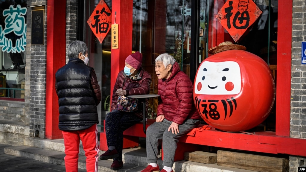 几位老人在北京一家餐馆外聊天。（2023年3月16日）