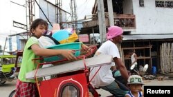 Warga membawa barang-barang mereka, menaiki becak ke pusat penampungan di Tacloban Filipina (4/12/2014) untuk menyelamatkan diri dari topan Hagupit yang diperkirakan akan mencapai Filipina Sabtu. 