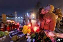 FILE — A woman and her child pray at a makeshift memorial of flowers and candles for Russian opposition leader Alexei Navalny in Zagreb, Croatia on March 1, 2024, the day of Navalny's funeral in Russia.