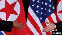 U.S. President Donald Trump and North Korea's leader Kim Jong Un meet at the start of their summit at the Capella Hotel on the resort island of Sentosa, Singapore, June 12, 2018.