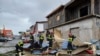 This handout photograph released by the Securite Civile on Dec. 15, 2024 and taken at an undisclosed location on Mayotte shows members of the French Civil Security cleaning debris after the cyclone Chido hit the archipelago.