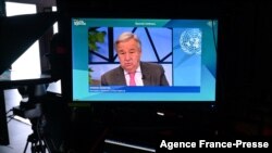 U.N. Secretary-General Antonio Guterres is seen on a TV screen addressing remotely the WEF Davos Agenda virtual sessions at the WEF's headquarters in Cologny near Geneva, Jan. 17, 2022.