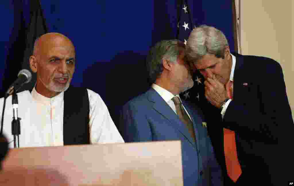 Afghan presidential candidate Ashraf Ghani Ahmadzai (left) speaks while other candidate Abdullah Abdullah (center) talks to U.S. Secretary of State John Kerry during a joint press conference in Kabul,&nbsp; Aug. 8, 2014.