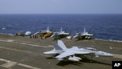 A U.S. Navy F-18 fighter jet lands on the deck of the USS Carl Vinson (CVN 70) aircraft carrier following a routine patrol off the disputed South China Sea, March 3, 2017. 