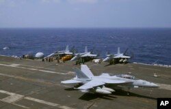 A U.S. Navy F-18 fighter jet lands on the deck of the USS Carl Vinson (CVN 70) aircraft carrier following a routine patrol off the disputed South China Sea, March 3, 2017.