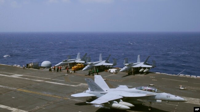 Các quan chức Philippines chứng kiến các chiến đấu cơ F-18 cất và hạ cánh trên hàng không mẫu hạm USS Carl Vinson.