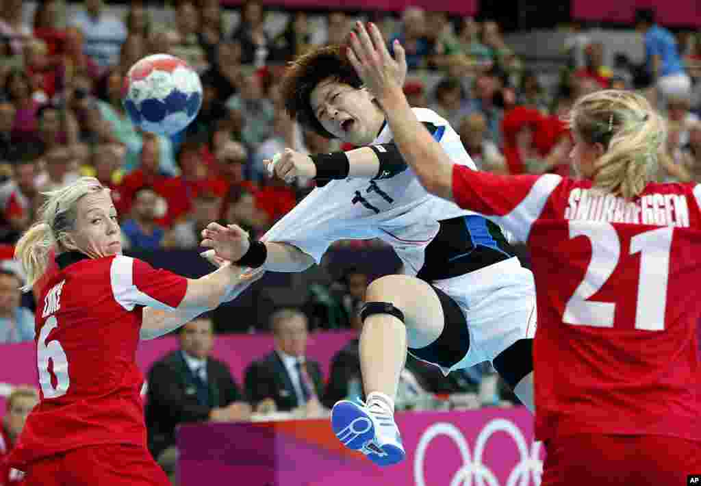 South Korea&#39;s Ryu Eun-hee, center, shoots the ball, between Norway&#39;s Goril Snorroeggen, right, and Lynn-Kristin Koren, left, during their women&#39;s handball preliminary match at the 2012 Summer Olympics, Aug. 1, 2012.