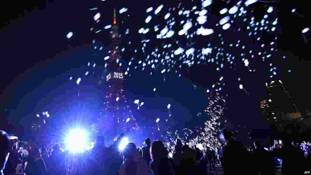 Une foule des gens lâchent des ballons à côté de la Tour de Tokyo pour célébrer la nouvelle année lors d&#39;une cérémonie du compte à rebours annuelle à Tokyo, Japon, le 1 janvier 2015.