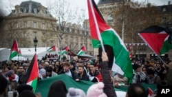 Para demonstran membawa bendera Palestina saat protes menentang keputusan Presiden AS Donald Trump yang mengakui Yerusalem sebagai ibukota Israel, di Lapangan Republik di Paris, Perancis, 9 Desember 2017.