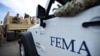 FILE - Department of Homeland Security personnel deliver supplies to Santa Ana community residents in the aftermath of Hurricane Maria in Guayama, Puerto Rico, Oct. 5, 2017.