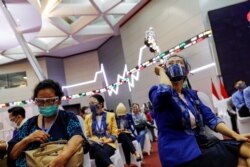 Para perempuan bereaksi saat menunggu dalam masa observasi setelah menerima vaksin Sinovac saat program vaksinasi massal COVID-19 di Bursa Efek Indonesia di Jakarta, 31 Maret 2021. (Foto: REUTERS/Willy Kurniawan)