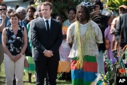 French President Emmanuel Macron pays tribute to the Kanak tribe of Hwadrilla, where the 19 Kanak militants are buried, on Ouvea Island, off New Caledonia, May 5, 2018, during ceremonies marking the 30th anniversary of when Kanak tribesmen took French police hostage on Ouvea island. Four gendarmes and 19 hostage-takers died.