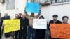 In this image sent to and verified by VOA Persian, Iranian teachers protest in the northeastern city of Mashhad, Feb, 14, 2019. The yellow sign calls for teachers to be paid at equal rates to other public-sector workers, while the blue sign says a teacher’s place isn't in prison.