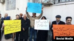 In this image sent to and verified by VOA Persian, Iranian teachers protest in the northeastern city of Mashhad, Feb, 14, 2019. The yellow sign calls for teachers to be paid at equal rates to other public-sector workers, while the blue sign says a teacher’s place isn't in prison.
