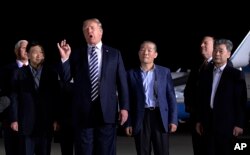 President Donald Trump speaks as he stands with Tony Kim, second left, Kim Dong Chul, center right, and Kim Hak Song, right, three Americans detained in North Korea for more than a year, after they arrived at Andrews Air Force Base in Md., May 10, 2018.