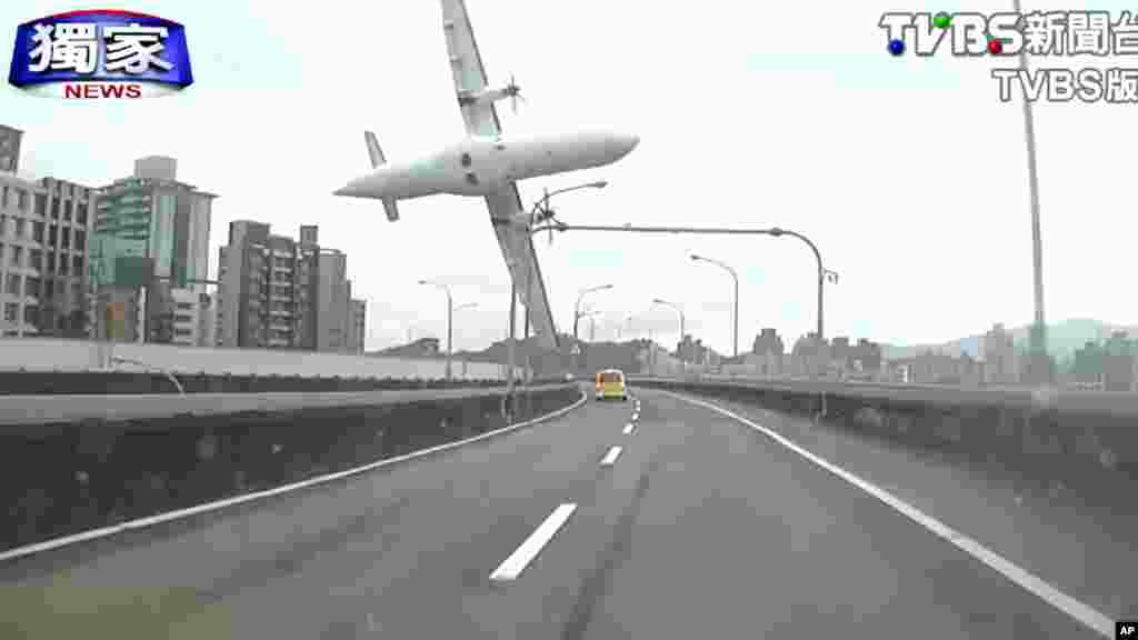 This image taken from video provided by TVBS shows a commercial airplane moments before it clipped an elevated roadway and careened into a river in Taipei, Taiwan, Feb. 4, 2015.