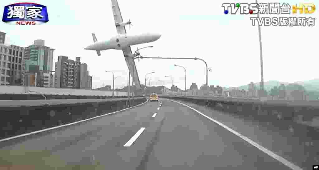 Những hình ảnh lấy từ video do đài truyền hình TVBS cung cấp cho thấy khoảnh khắc chiếc máy bay thương mại va quẹt vào một cây cầu và lao xuống con sông Cơ Long ở Đài Bắc, Đài Loan.