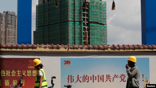 中国工人从云南省昆明市一处建筑工地旁走过。（2019年9月17日）