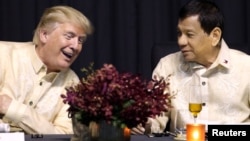 U.S. President Donald Trump speaks with Philippines President Rodrigo Duterte during the dinner marking ASEAN's 50th anniversary in Manila, Philippines, Nov. 12, 2017.
