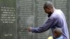 FILE - A survivor pays homage to people killed in the 1998 bombing of the U.S. embassy in Kenya, at the memorial wall in Nairobi, May 2, 2011.