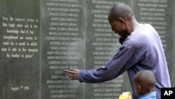 FILE - A survivor pays homage to people killed in the 1998 bombing of the U.S. embassy in Kenya, at the memorial wall in Nairobi, May 2, 2011.