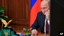 FILE - Russian President Vladimir Putin speaks on the phone at the Kremlin, in Moscow, Russia, Nov. 15, 2017.