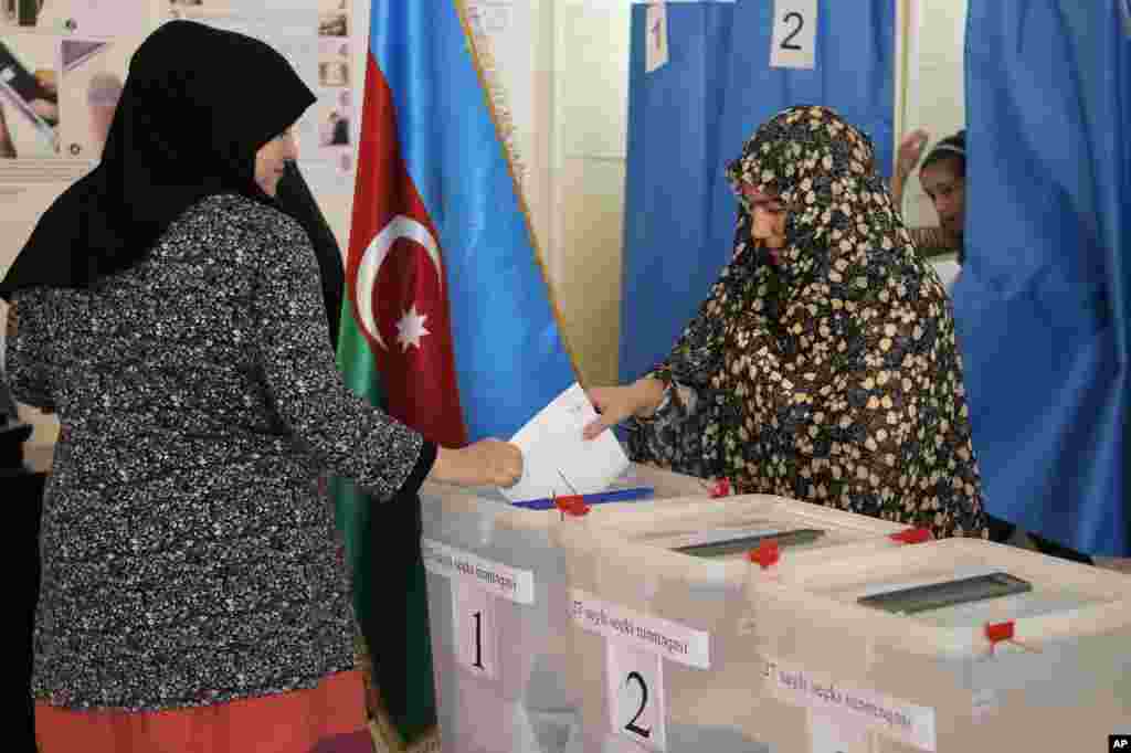 Women cast their ballots at a polling station in Nardaran, north of Baku, Azerbaijan, Oct. 9, 2013. 