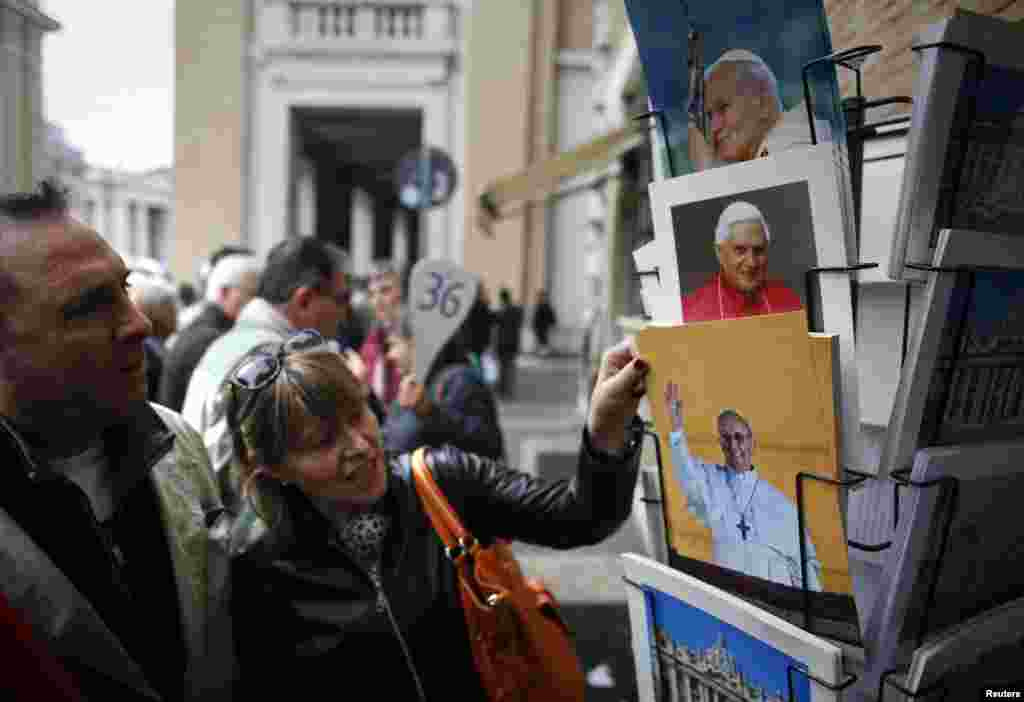 Tourists view newly-printed pictures of the newly-elected Pope Francis, Cardinal Jorge Mario Bergoglio of Argentina, at a souvenir shop near the Vatican in Rome.