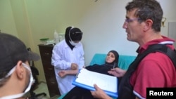 A UN chemical weapons expert meets a person affected by an apparent gas attack, at a hospital where she is being treated in Damascus' suburb of Zamalka, August 28, 2013.