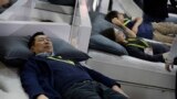 FILE - People try out smart beds during CES International, Jan. 7, 2017, in Las Vegas, Nevada. The bed adjusts the comfort and firmness depending on the user's position. It also warms the foot area before bedtime.