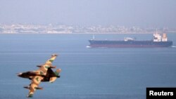 ایک ایرانی طیارہ خلیجِ عمان میں پرواز کر رہا ہے۔ پسِ منظر میں ایک آئل ٹینکر بھی نظر آ رہا ہے۔ (فائل فوٹو)