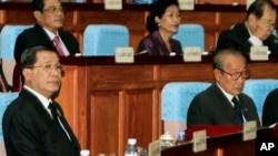 Cambodian Prime Minister Hun Sen, left, sits inside the session hall of the National Assembly with lawmakers from his Cambodian People's Party, in Phnom Penh, Cambodia, Sept. 24, 2013.