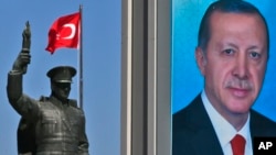 A statue of modern Turkey's founder Mustafa Kemal Ataturk and a poster of Turkey's President Recep Tayyip Erdogan for the upcoming referendum is seen in his hometown city of Rize, April 4, 2017.