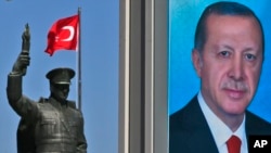 A statue of modern Turkey's founder, Mustafa Kemal Ataturk, and a poster of Turkish President Recep Tayyip Erdogan are seen in his hometown city of Rize ahead of an upcoming referendum, April 4, 2017.
