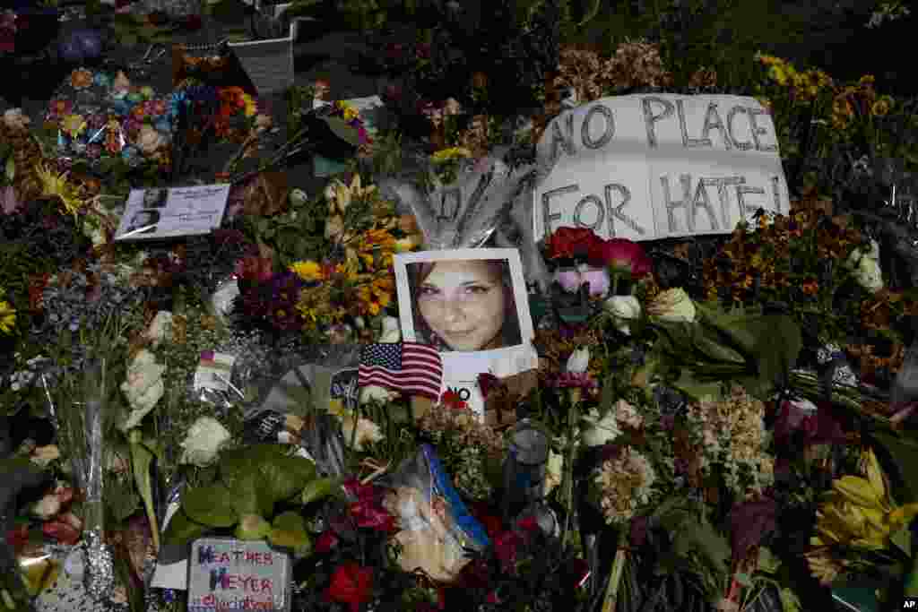 ภาพถ่ายของ Heather Heyer หญิงเคราะห์ร้ายที่เสียชีวิตในเหตุคนร้ายขับรถพุ่งชนผู้คนที่ประท้วงในเมืองชาร์ล็อตส์วิว รายล้อมด้วยดอกไม้ไว้อาลัยเธอ บริเวณ Paramount Theater ในเมืองชาร์ล็อตส์วิว รัฐเวอร์จิเนีย